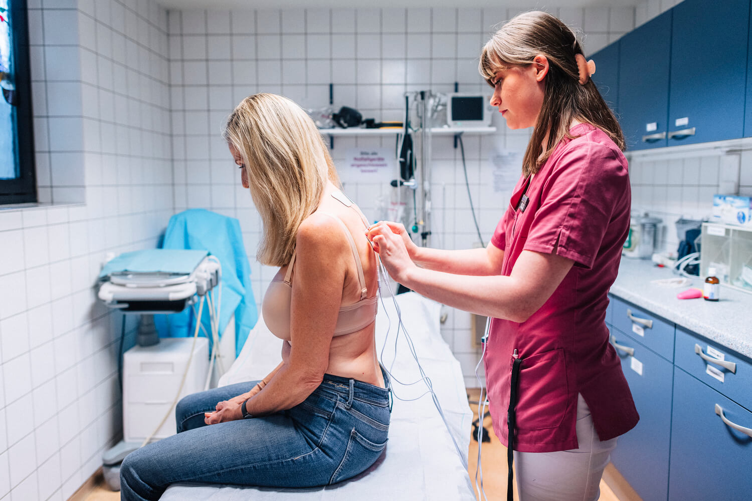 Eine Patientin erhält Elektroden am Rücken für eine TENS-Behandlung